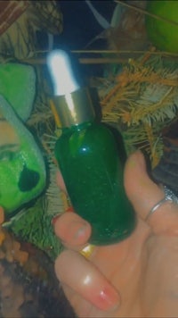 a person holding a bottle of green elixir