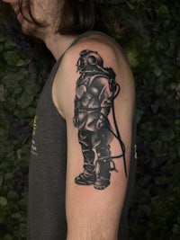 a man with a black and grey tattoo on his arm