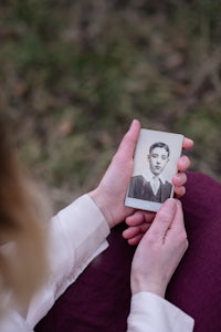 a woman holding a photo of a young man