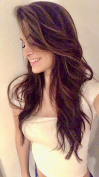 a woman with long brown hair is posing for a selfie