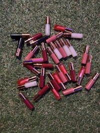 a bunch of lipsticks laying on the grass