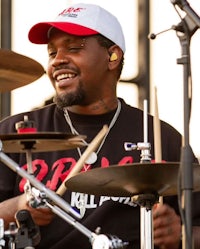 a man playing drums with a hat on