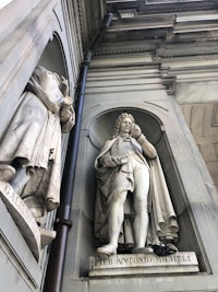 two statues on the side of a building