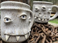 two mugs with chains and eyes on them