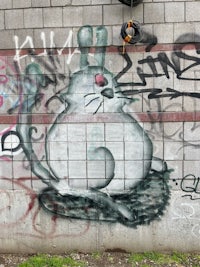 graffiti on a wall with a cat on it