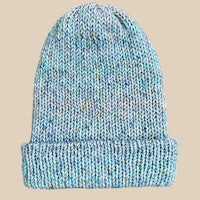 a blue knitted beanie on a beige background