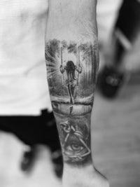 a black and white photo of a man with a tattoo on his forearm