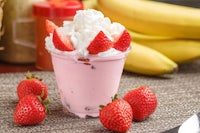 a strawberry milkshake with whipped cream and bananas