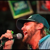 a bearded man singing into a microphone