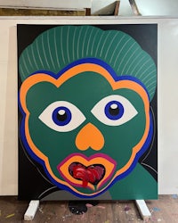 a painting of a green face with blue eyes