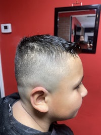 a boy's hair being cut in a barber shop