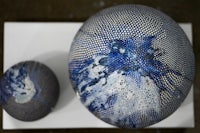 two blue and white spheres on a white surface
