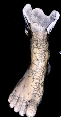 a statue of a foot with cracks in it