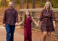 a family walking on a bridge in the fall