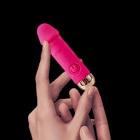 a woman's hand holding a pink vibrator