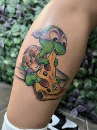 a tattoo of a nintendo ninja turtle eating pizza