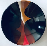 a black and brown plate with a red and orange design