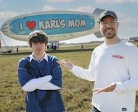 two men standing in front of a balloon with the word i love karl's mom