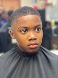 a young boy is sitting in a barber shop
