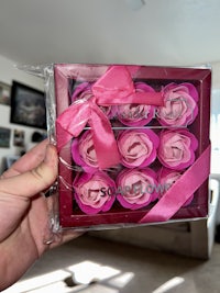 a person holding a box of pink roses