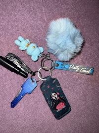 a blue keychain with a teddy bear on it