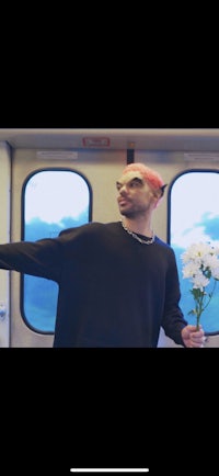 a man standing on a train with flowers in his hands