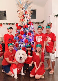 a group of people posing in front of a christmas tree