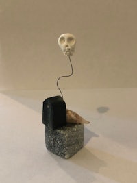 a sculpture with a skull on top of a block