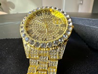 a gold watch with diamonds and roman numerals