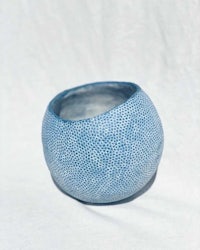 a blue ceramic bowl on a white surface