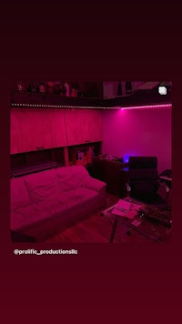 a room with pink lights and a couch