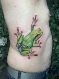 a green frog tattoo on a man's stomach