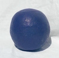 a blue ball sitting on top of a white surface