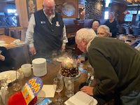 a man blowing out a candle on a birthday cake