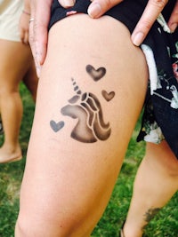 a woman with a tattoo of a unicorn on her thigh