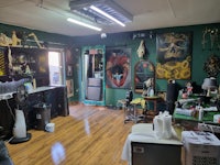 a tattoo shop with a lot of tattoos on the walls