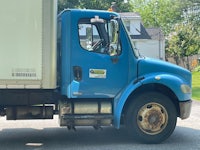 a blue truck parked on a street