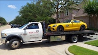 a yellow tow truck with a yellow sports car on it