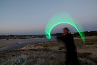 a man throwing a green frisbee