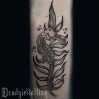 a tattoo of a seahorse on the forearm
