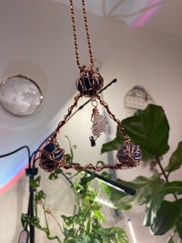 a copper pendant hanging from a plant in a room