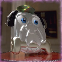 a silver dog with blue eyes sitting on top of a table