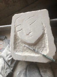 a piece of stone with a face on it