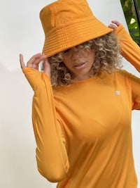 a woman wearing a yellow shirt and hat