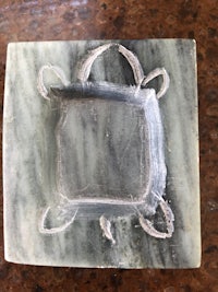 a square piece of green jade with a turtle on it