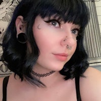 a woman with black hair and piercings