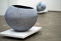 a blue and white ceramic sphere on a white pedestal