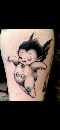 a tattoo of a little girl with a bat on her thigh