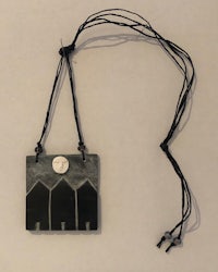 a black and white necklace with a black and white house on it
