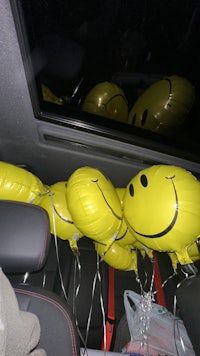 a bunch of yellow balloons with smiley faces on them